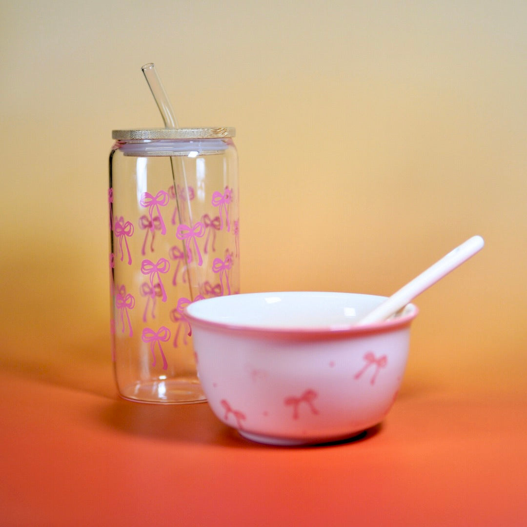 Servies set met lepel, glazen beker met roze strikjes en wit kommetje voor verschillende maaltijden