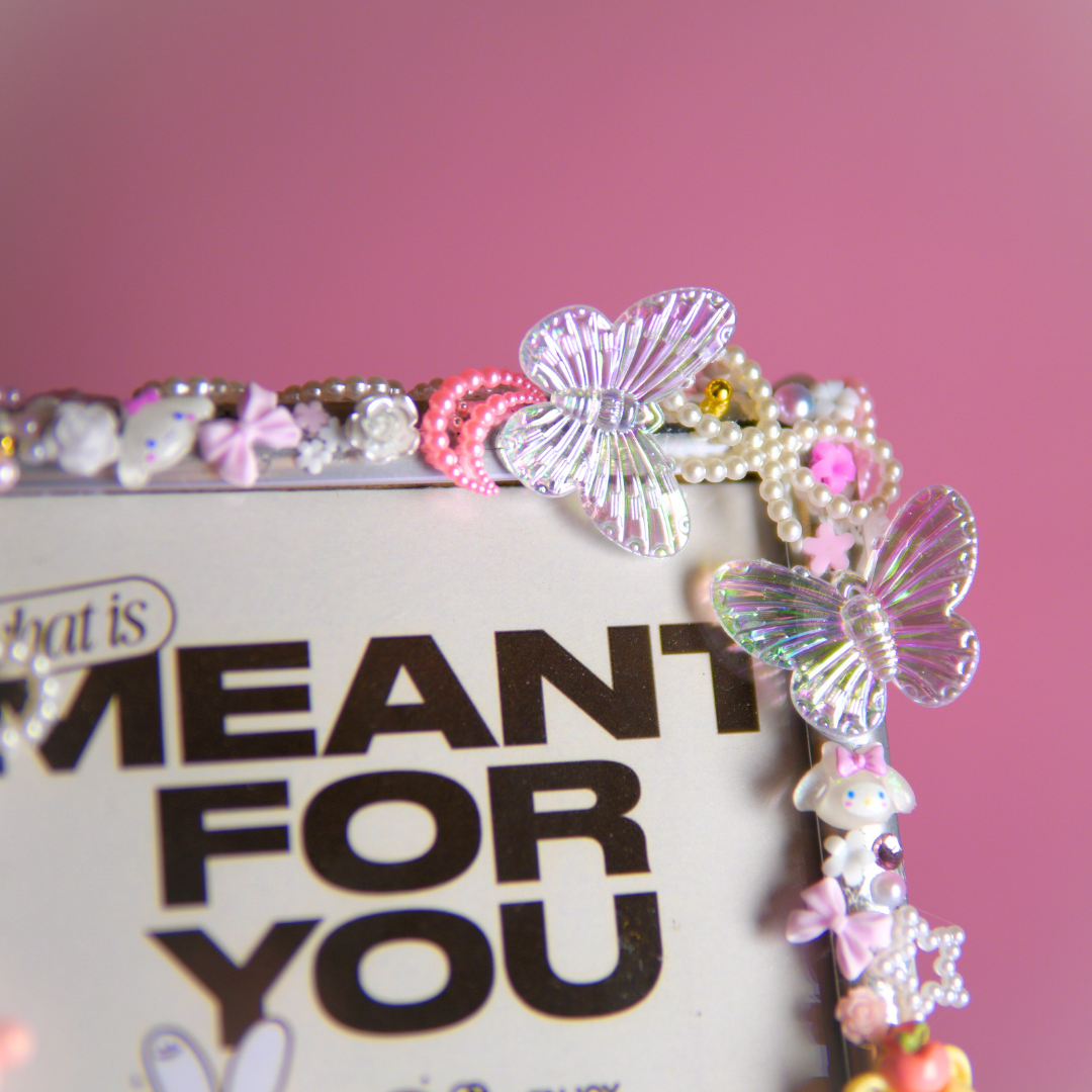 Roze bedeltjes en materialen voor het maken van een fotolijst