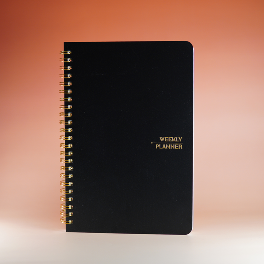 Zwarte weekplanner open op bureau voor dagelijkse planning